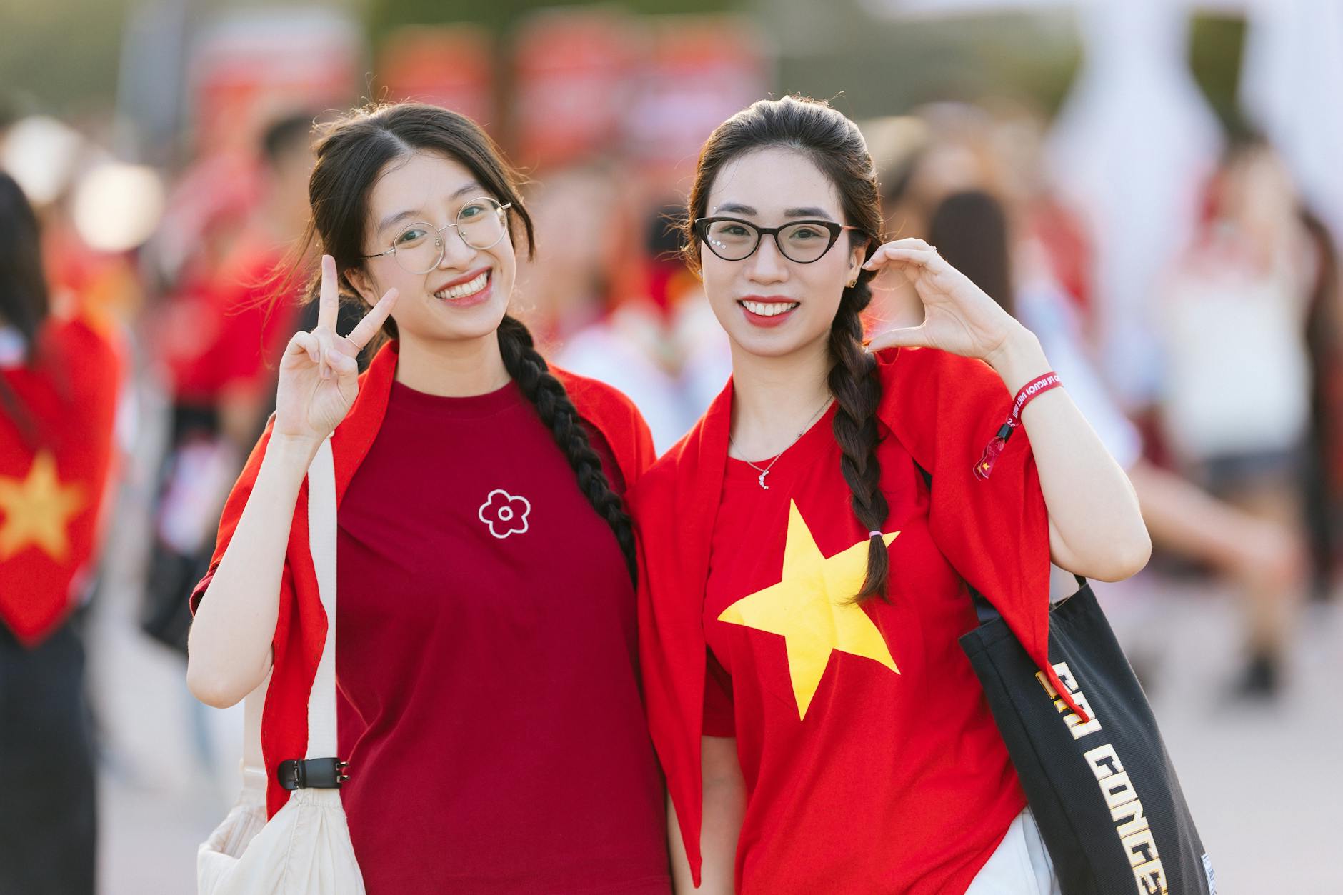 Dwie uśmiechnięte kobiety w czerwonych koszulkach z gwiazdą Wietnamu