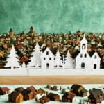 Papierowe zimowe miasteczko na tle ośnieżonej, miniaturowej wioski