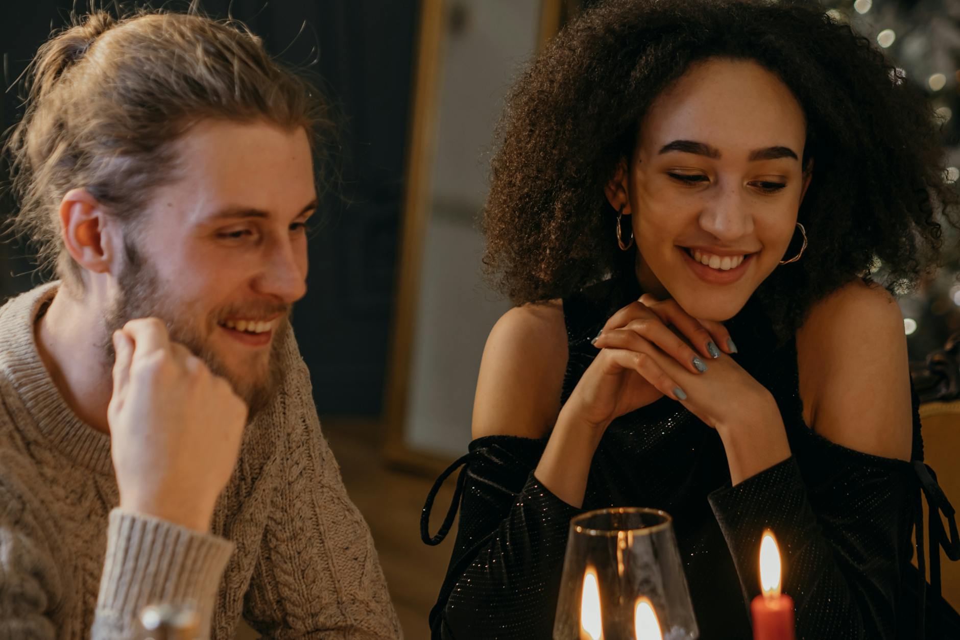 Uśmiechnięta para przy romantycznej kolacji przy świecach