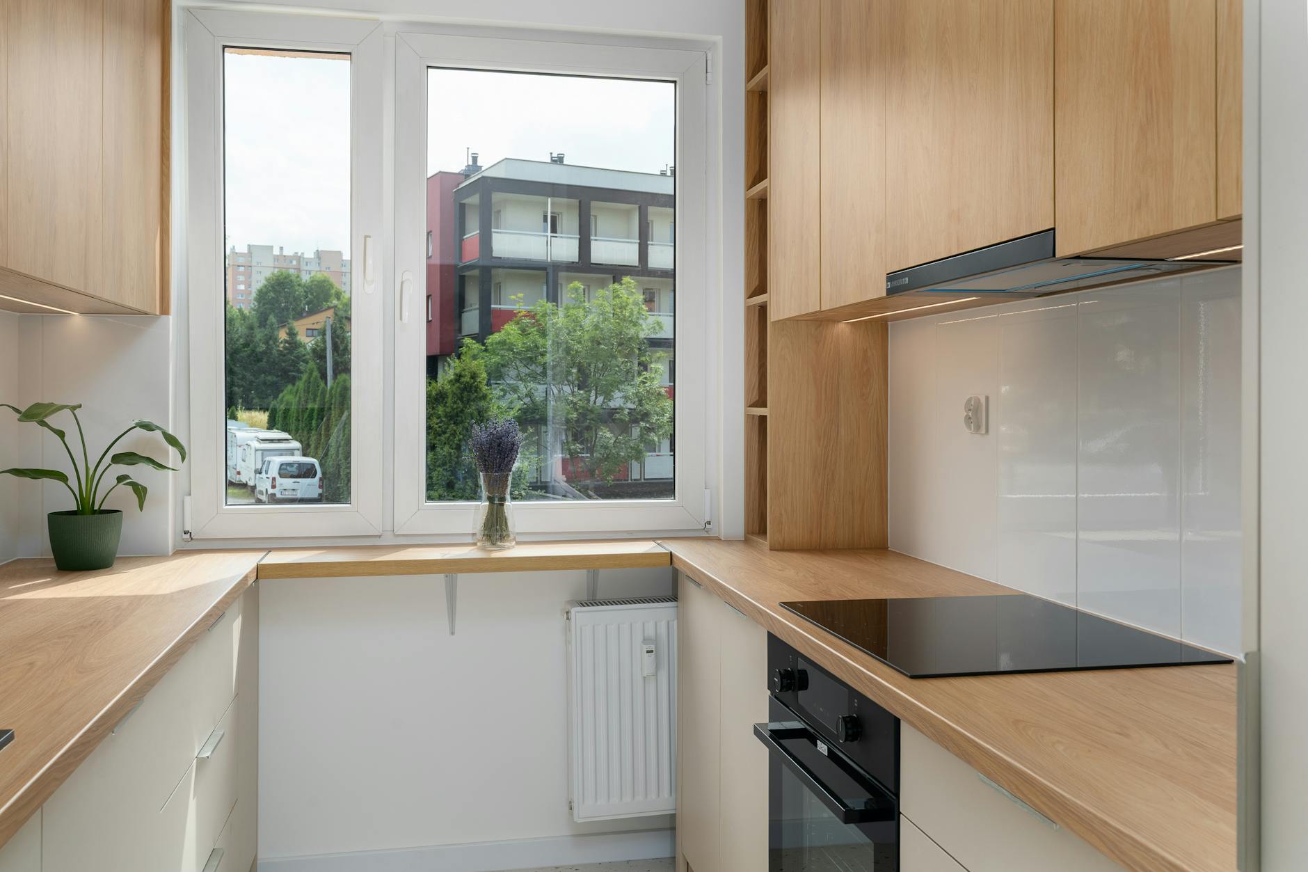 Nowoczesna kuchnia z drewnianymi szafkami i widokiem na zieleń w Krakowie