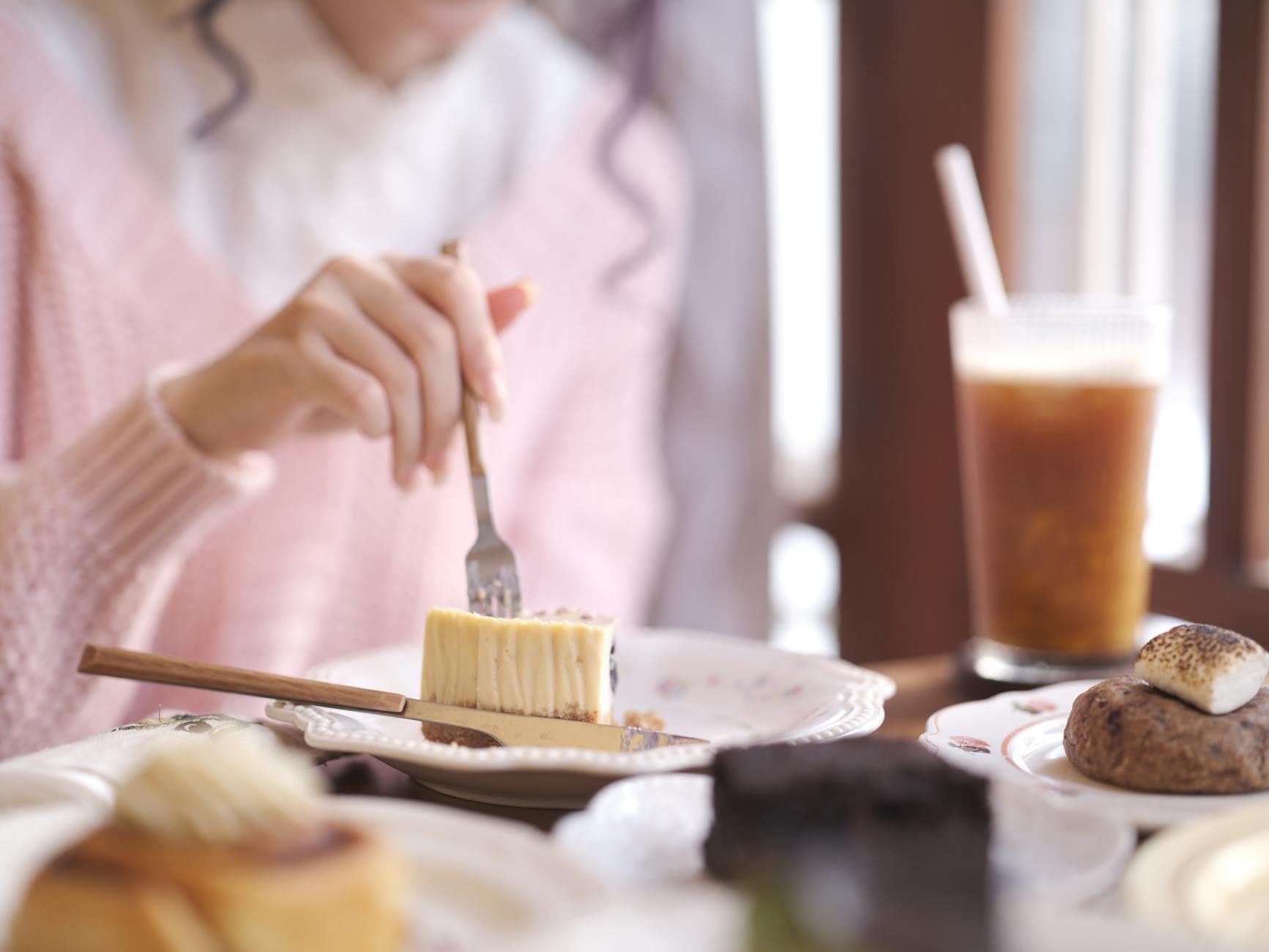Osoba je ciasto i pije mrożoną kawę w przytulnej kawiarni