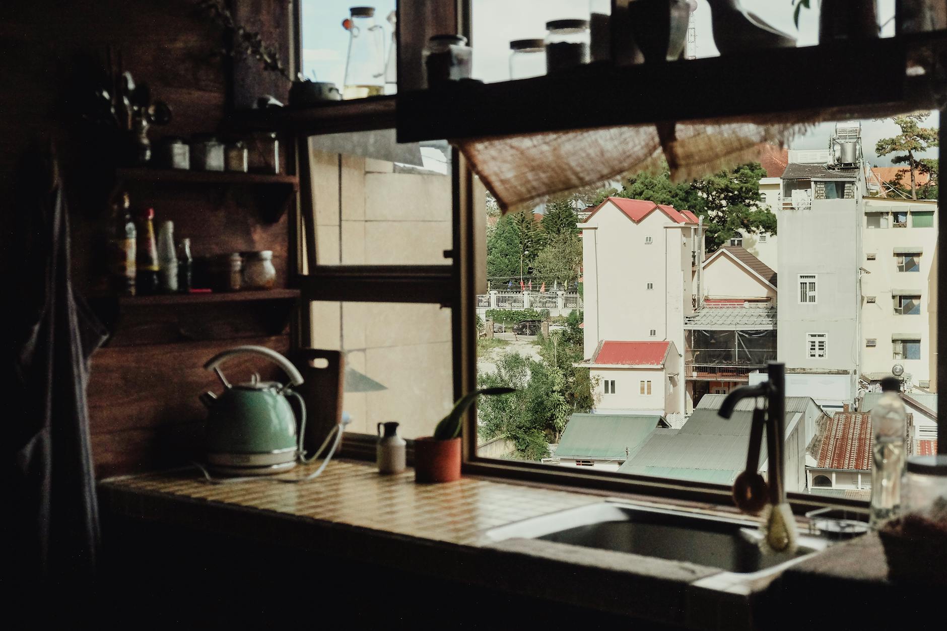 Przytulna kuchnia z oknem na spokojne miejskie kamienice