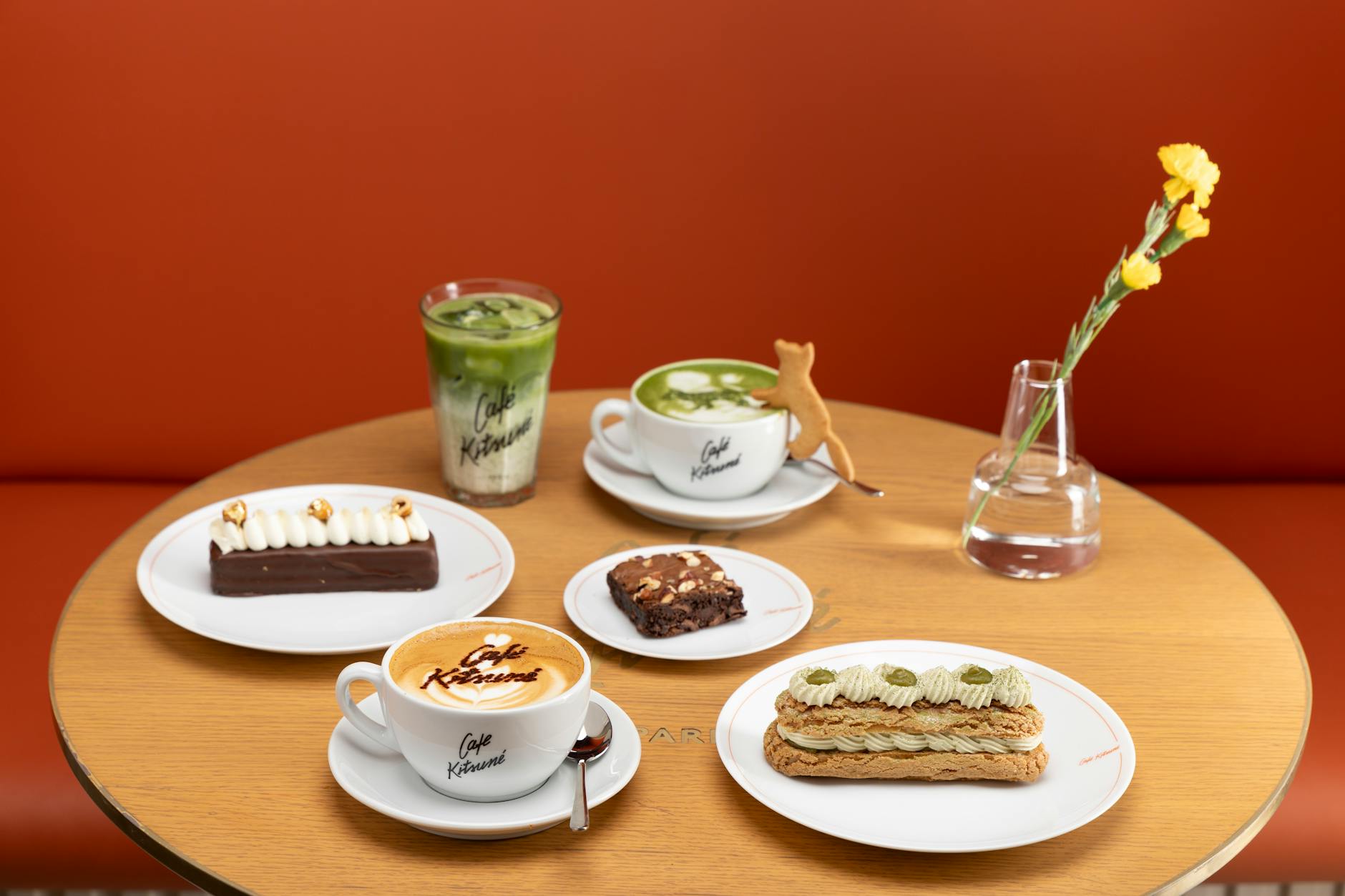 Stylowy stolik w kawiarni z deserami, napojami i wazonem z kwiatami
