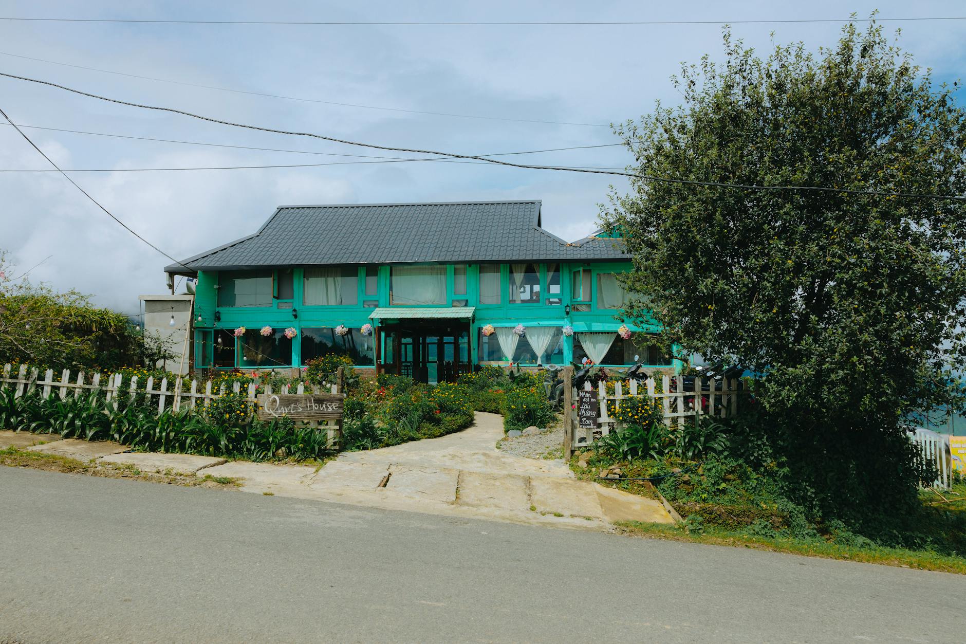 Zielony pensjonat wśród bujnej roślinności przy cichej wiejskiej drodze