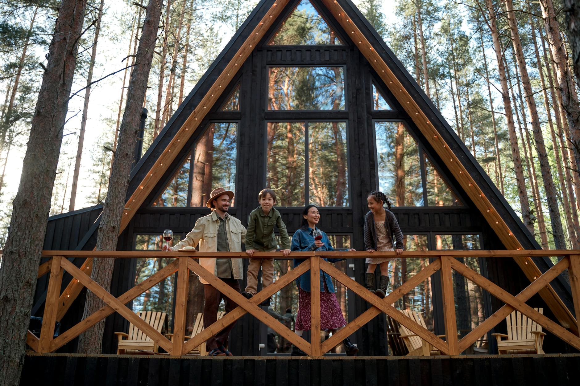 Rodzina odpoczywa przy nowoczesnym domku typu A-frame w lesie